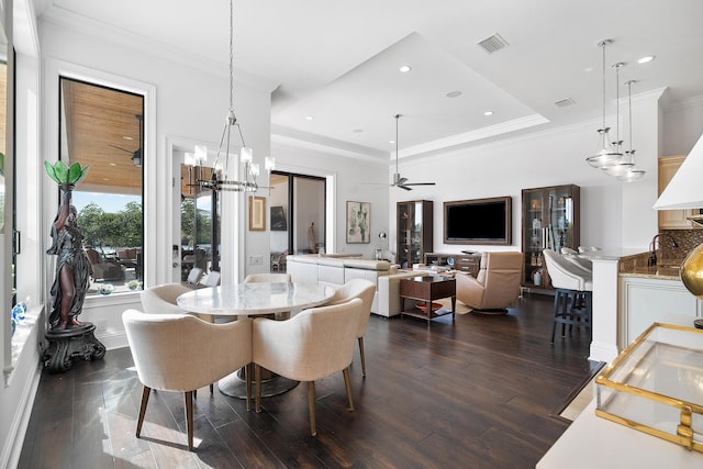 dining area with a raised ceiling, crown molding, ceiling fan, and dark hardwood / wood-style flooring