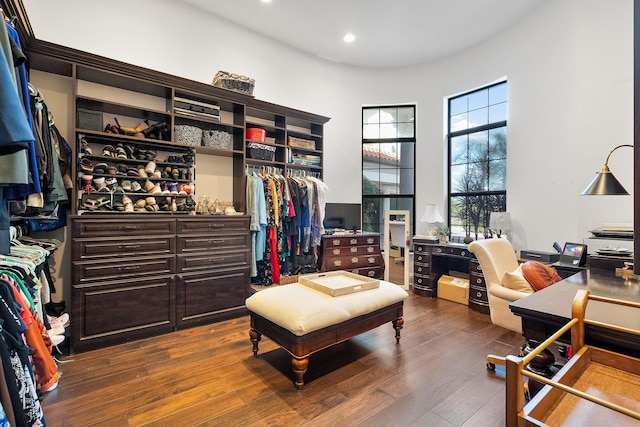 walk in closet featuring wood-type flooring and a high ceiling