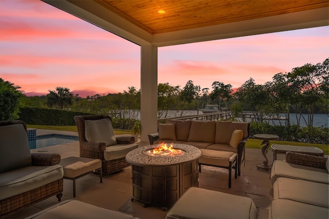 patio terrace at dusk featuring an outdoor living space with a fire pit