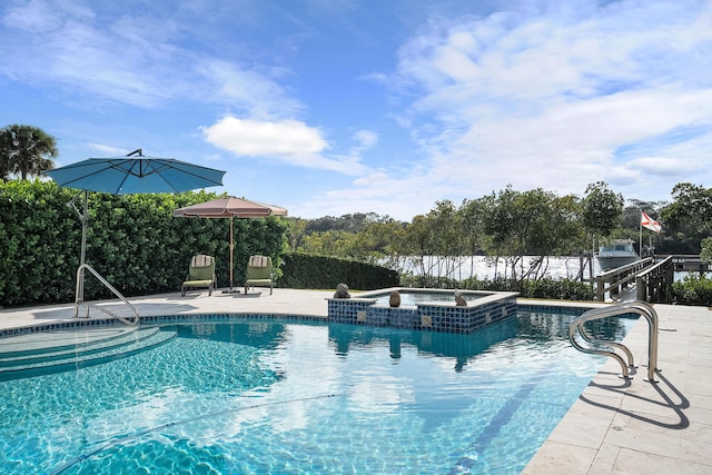 view of swimming pool with an in ground hot tub, a water view, and a patio