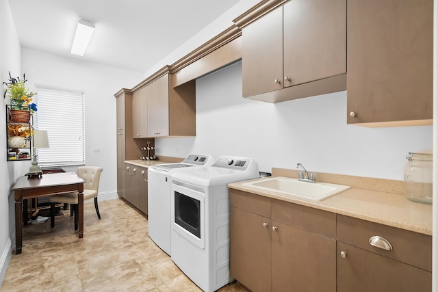 clothes washing area featuring cabinets, sink, and washer and clothes dryer