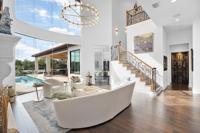 living room featuring a high ceiling, hardwood / wood-style floors, and a chandelier