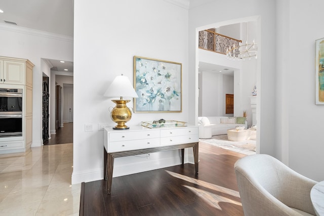 hallway featuring a high ceiling, crown molding, and light hardwood / wood-style flooring