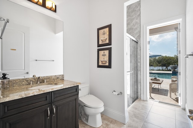 bathroom featuring tile patterned flooring, walk in shower, vanity, and toilet