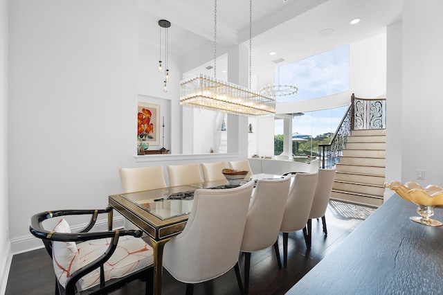 dining room featuring a towering ceiling and dark hardwood / wood-style flooring