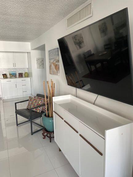 living room with light tile patterned floors and a textured ceiling