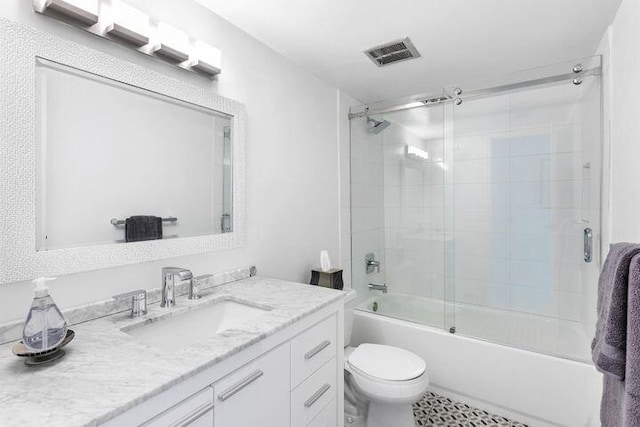 full bathroom with vanity, shower / bath combination with glass door, and toilet