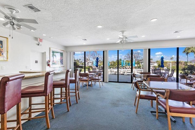 dining area with ceiling fan, carpet floors, and a textured ceiling