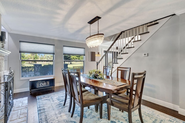 dining area featuring a textured ceiling, ornamental molding, and a chandelier