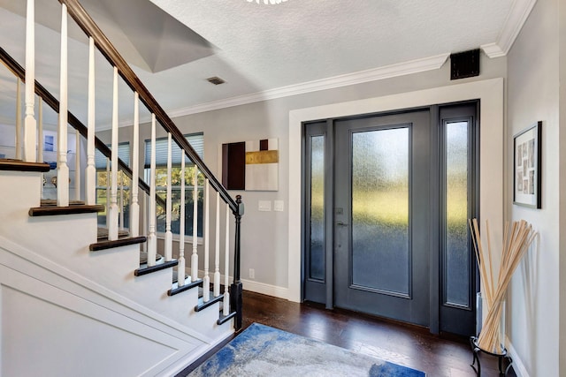 entrance foyer with crown molding, a healthy amount of sunlight, dark hardwood / wood-style floors, and a textured ceiling