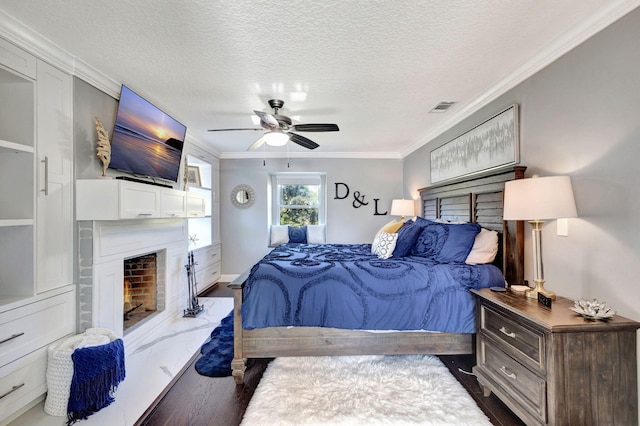 bedroom with crown molding, dark hardwood / wood-style floors, a textured ceiling, and ceiling fan