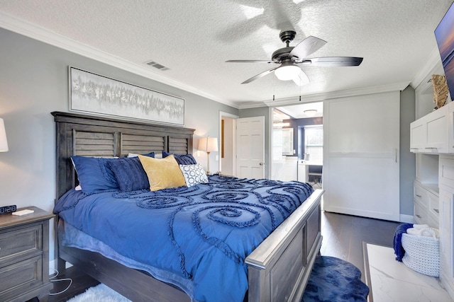 bedroom with dark wood-type flooring, ensuite bathroom, a textured ceiling, ornamental molding, and ceiling fan