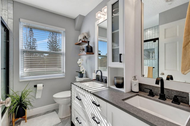 bathroom with an enclosed shower, vanity, and toilet