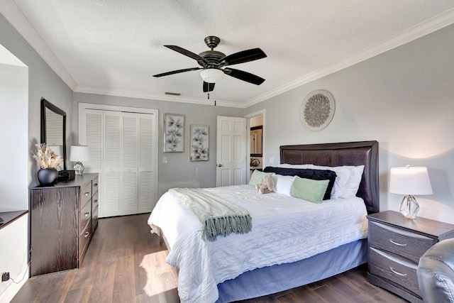 bedroom with dark wood-type flooring, a textured ceiling, ornamental molding, a closet, and ceiling fan