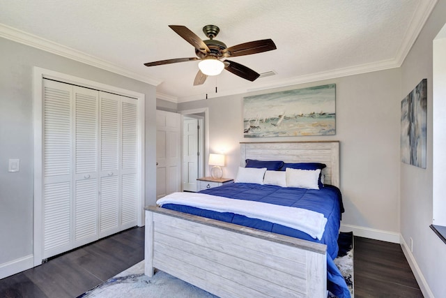 bedroom with dark wood-type flooring, ornamental molding, a closet, and ceiling fan