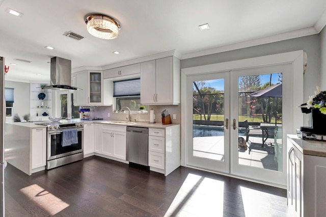 kitchen featuring sink, appliances with stainless steel finishes, white cabinets, island exhaust hood, and dark hardwood / wood-style flooring