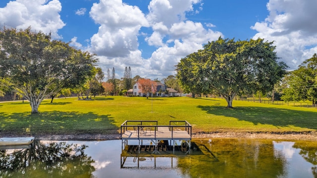 view of dock featuring a water view and a yard