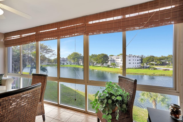 sunroom / solarium with a water view, a wealth of natural light, and ceiling fan