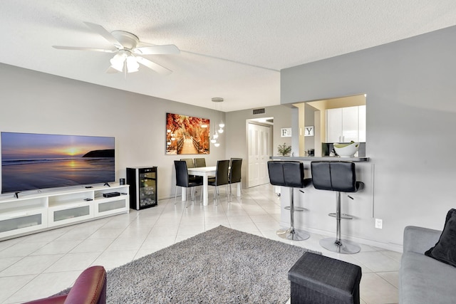 tiled living room featuring ceiling fan and a textured ceiling