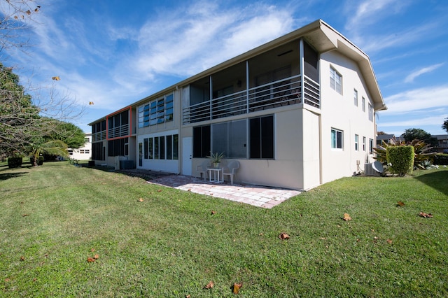 rear view of property featuring a yard, central AC, and a patio area