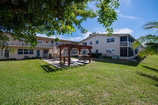 back of house with a pergola, a patio, and a lawn