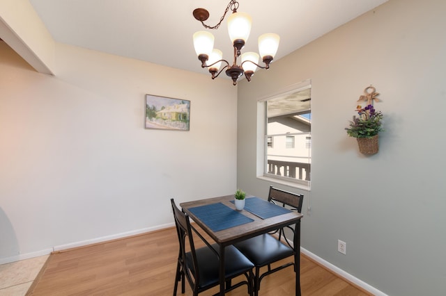 dining area with light hardwood / wood-style floors and a chandelier