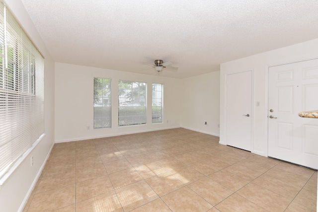 tiled empty room featuring a textured ceiling and ceiling fan