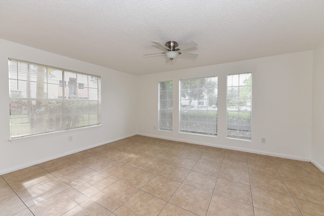 tiled spare room with ceiling fan and a textured ceiling