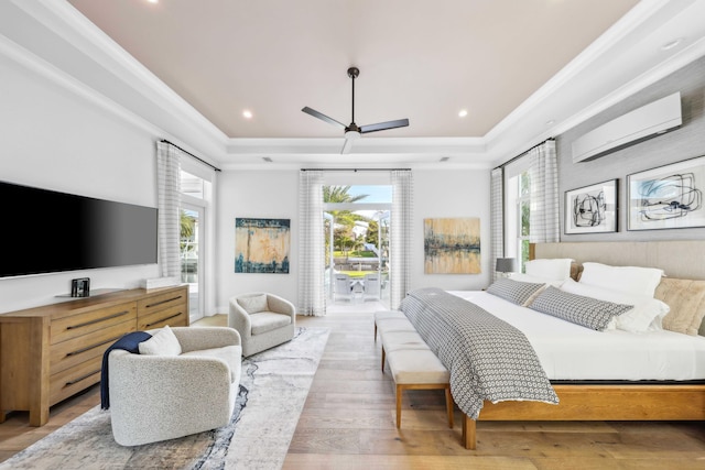 bedroom featuring multiple windows, access to outside, a wall unit AC, and a raised ceiling