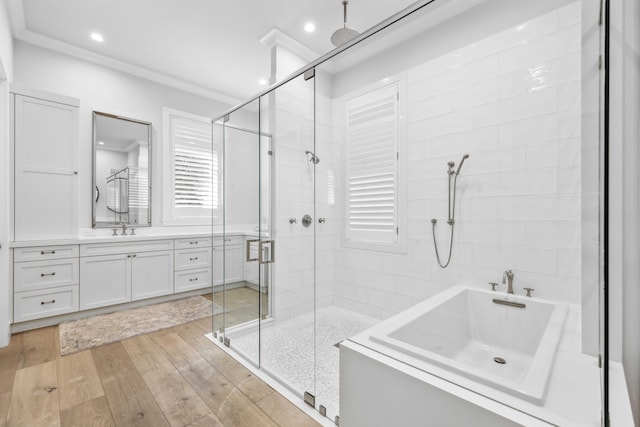 bathroom with hardwood / wood-style flooring, ornamental molding, shower with separate bathtub, and vanity