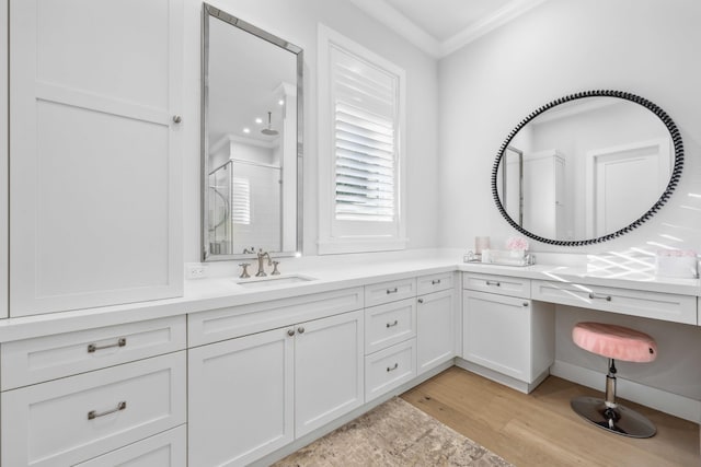 bathroom featuring ornamental molding, vanity, an enclosed shower, and hardwood / wood-style floors