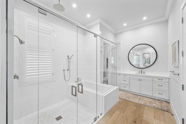 bathroom with hardwood / wood-style flooring, vanity, crown molding, and walk in shower