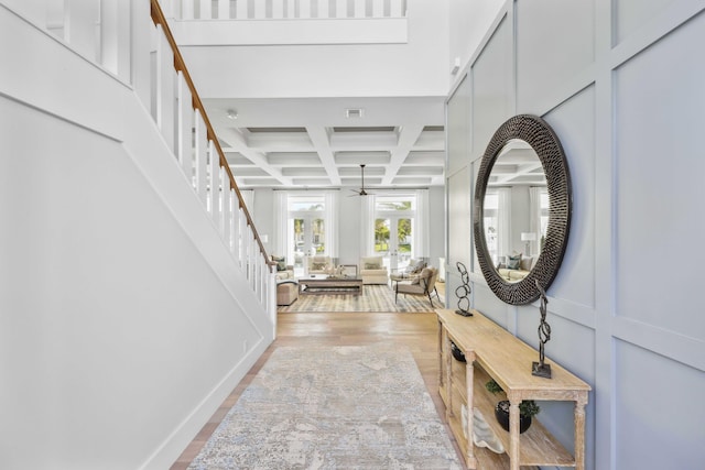 foyer featuring hardwood / wood-style flooring, coffered ceiling, and beamed ceiling