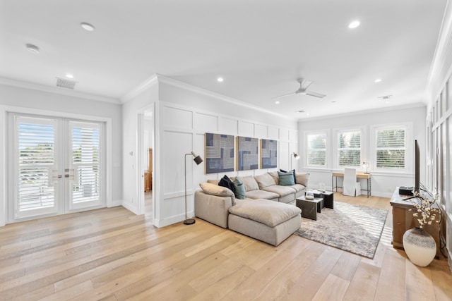 living room with french doors, ornamental molding, a healthy amount of sunlight, and light hardwood / wood-style flooring