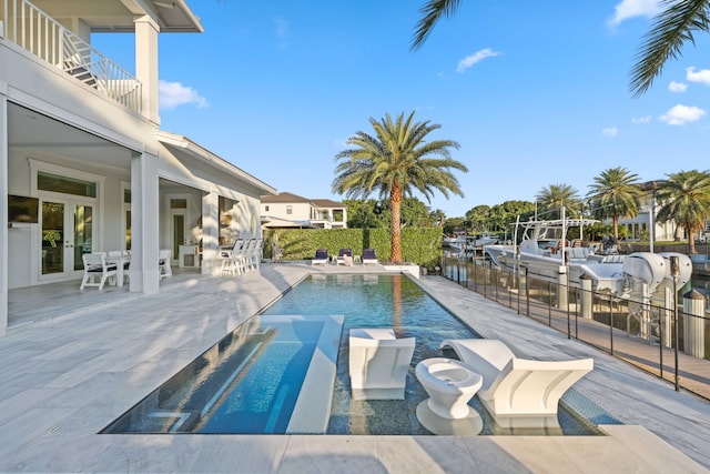 view of swimming pool with french doors and a patio area