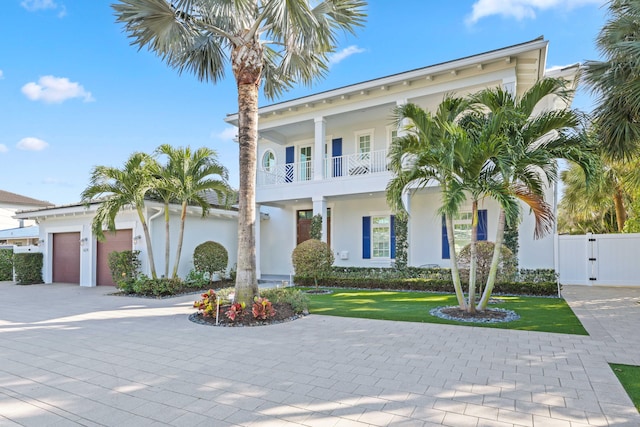 view of front of home featuring a balcony, a garage, and a front lawn