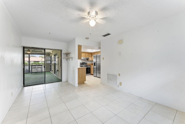 unfurnished room with light tile patterned floors, a textured ceiling, and ceiling fan