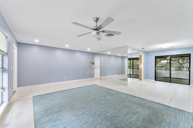 spare room featuring light tile patterned floors, a textured ceiling, and ceiling fan