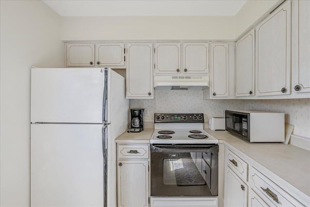 kitchen featuring white cabinetry, range with electric cooktop, and white fridge