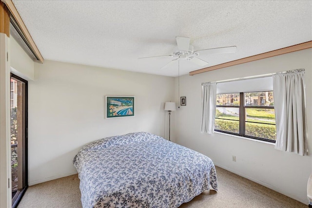 carpeted bedroom featuring ceiling fan and a textured ceiling