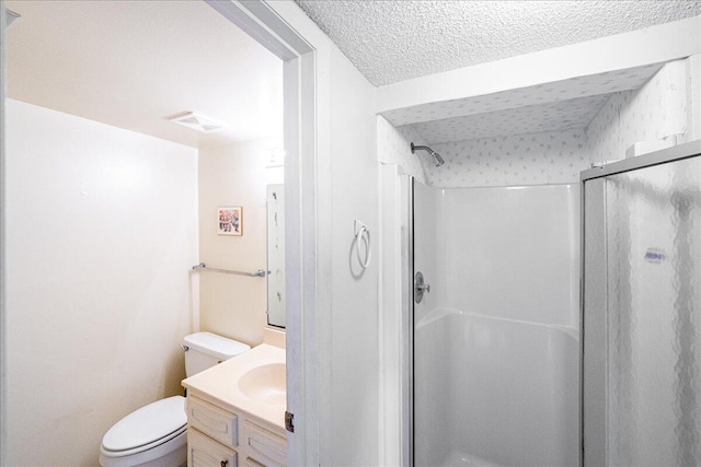 bathroom featuring vanity, toilet, a textured ceiling, and walk in shower