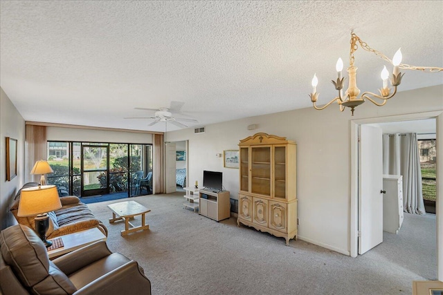 living room with ceiling fan with notable chandelier, carpet floors, and a textured ceiling