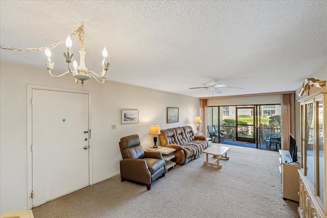 carpeted living room with ceiling fan with notable chandelier and a textured ceiling