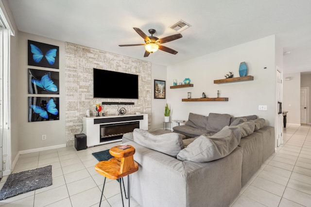 living room featuring light tile patterned floors, a fireplace, and ceiling fan