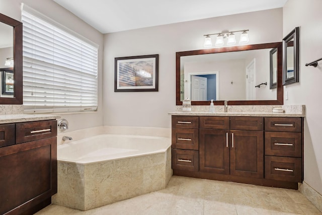 bathroom featuring vanity, tiled bath, and tile patterned flooring