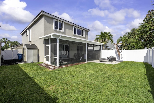 back of property with a patio, a sunroom, a yard, and a storage shed