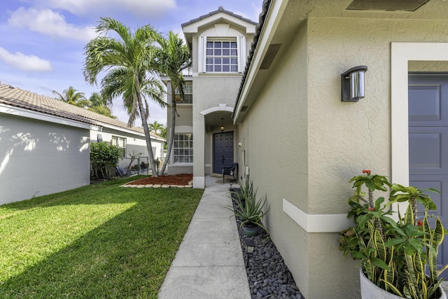 view of exterior entry featuring a yard