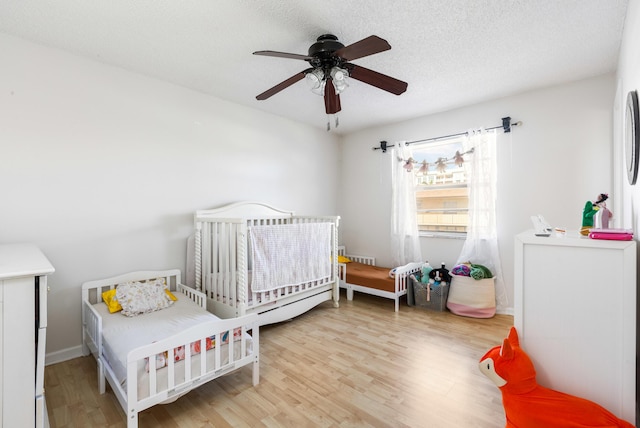 bedroom featuring ceiling fan, wood-type flooring, and a textured ceiling