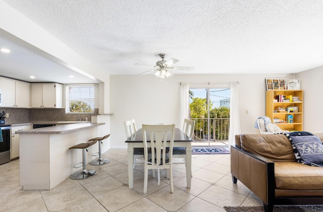 tiled dining area featuring a textured ceiling and ceiling fan