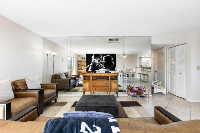 tiled living room featuring a textured ceiling